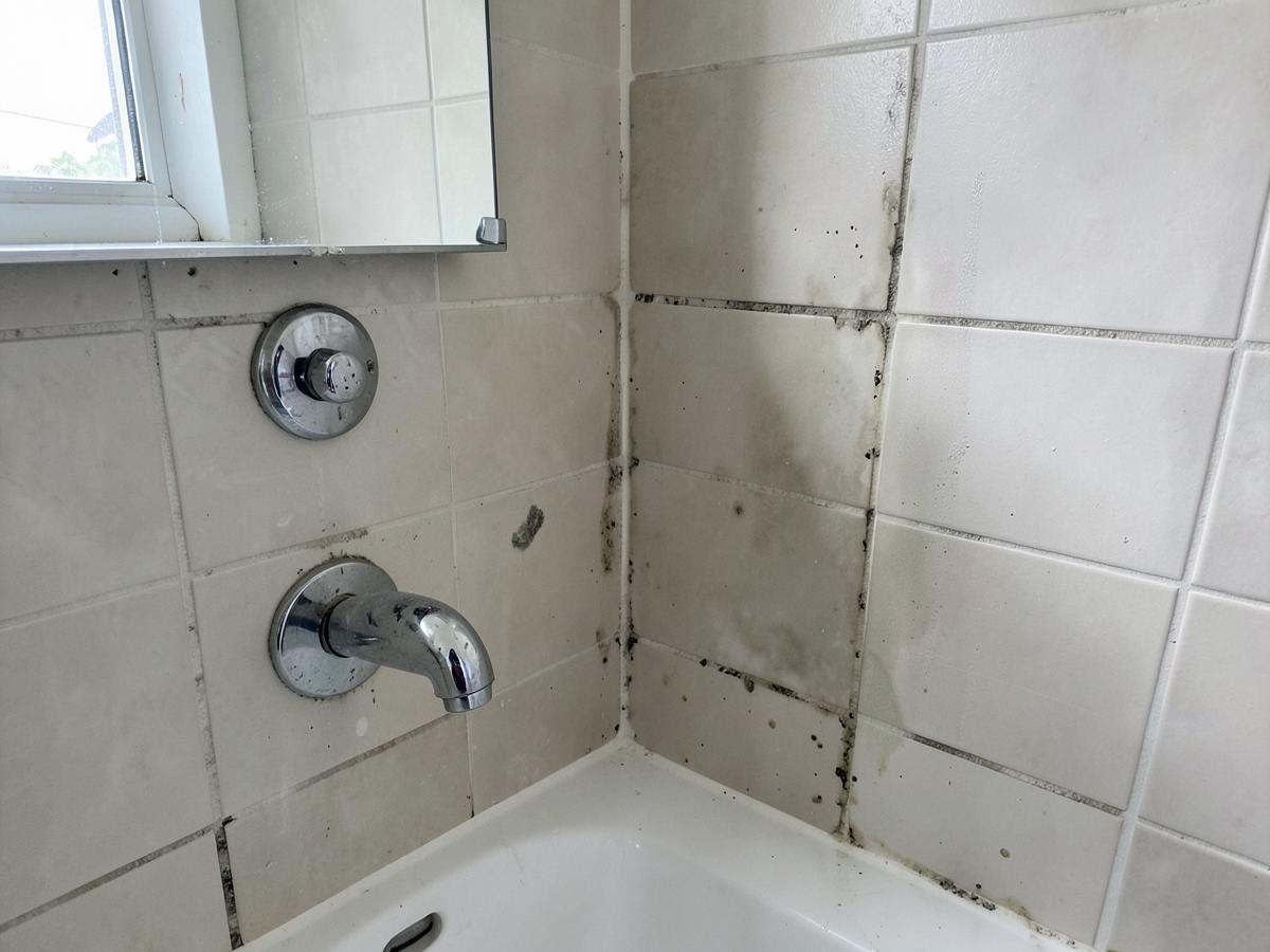 Bathroom tile with soap scum and staining before a deep cleaning